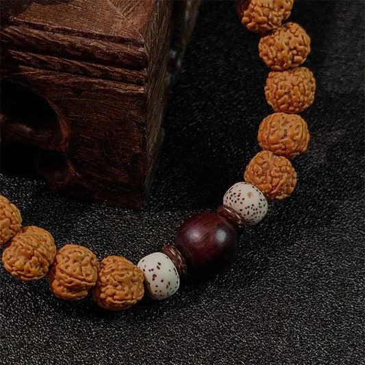 Genuine Bodhi seed meditation bracelet for mindfulness and spiritual protection, featuring natural beads and a tassel, laid on a wooden surface.