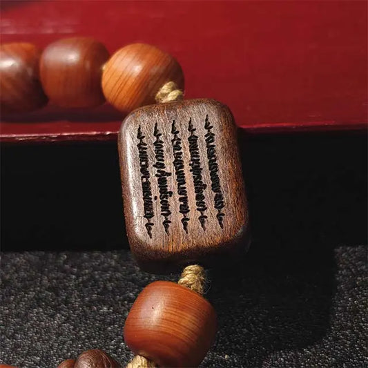 Close-up of a handcrafted wooden mala bracelet, featuring natural Thuja and dark Black Persimmon wood beads. An elegant yoga and mindfulness accessory.