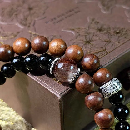A double strand beaded bracelet featuring Black Obsidian and Super Seven (also known as Sacred Seven) crystals, accented with natural Thunderstruck Wood. This healing energy and protection bracelet is designed for grounding and spiritual well-being.