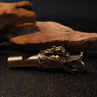 Handcrafted brass dragon whistle keychain with vintage dragon head design used as key or backpack accessory