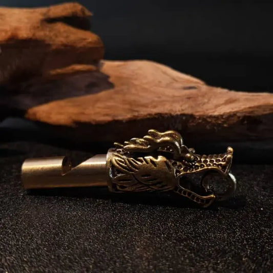 Handcrafted brass dragon whistle keychain with vintage dragon head design used as key or backpack accessory