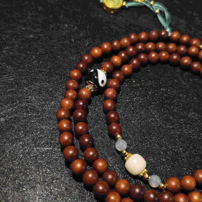 A model wearing the versatile Lightning Struck Wood Mala jewelry set.  The necklace can be worn long or the beads triple-wrapped as a bracelet, showcasing its elegant and spiritual Tibetan style.