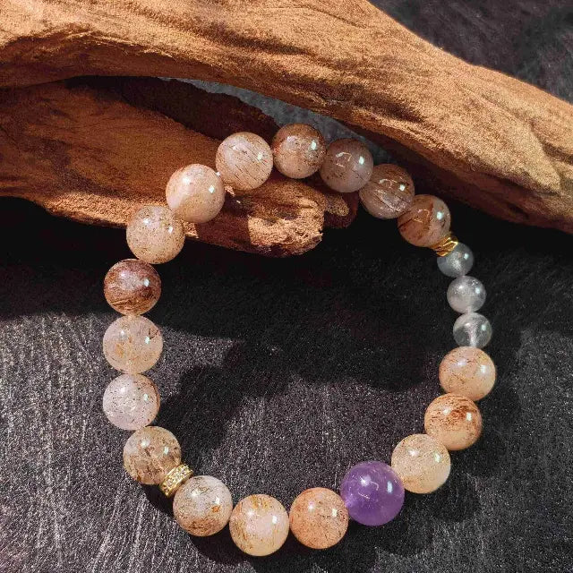 Handcrafted Moonstone Amethyst Super Seven crystal bracelet for chakra balancing and meditation, showcasing natural stones in shades of purple and white on a stretch cord.