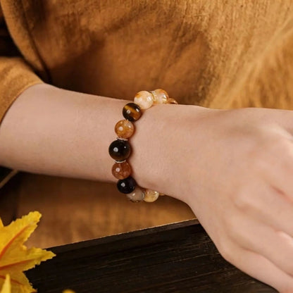 Side view of a vintage-style healing crystal bracelet on a wrist, displaying the chatoyancy of tiger's eye beads.