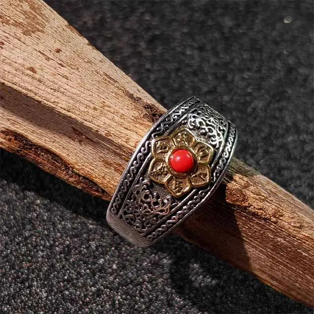 Close-up detail of Red Agate stone with engraved Om Mani Padme Hum mantra on Tibetan ring, showcasing handcrafted spiritual design.
