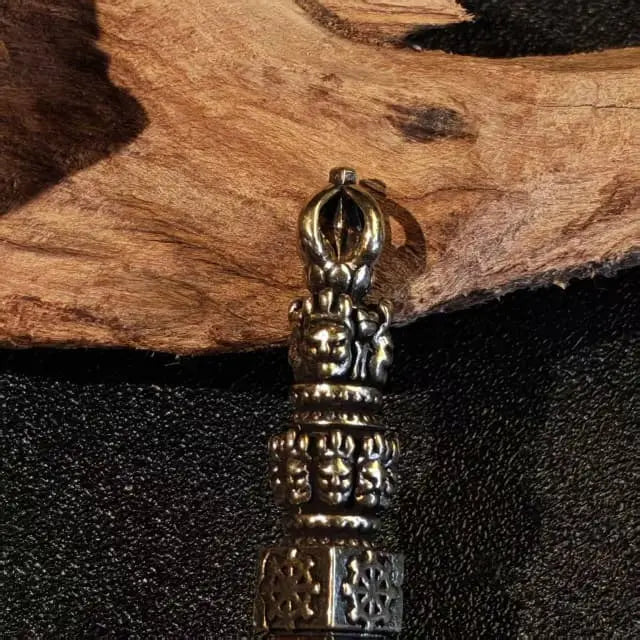 close up of handcrafted tibetan style brass dorje pendant with intricate vintage carving details