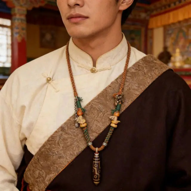 Man wearing Tibetan style Dzi bead necklace with braided rope and traditional ethnic design, spiritual jewelry close-up