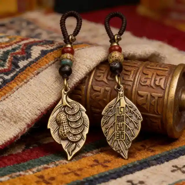 Handmade Tibetan-style leaf pendant earrings with vintage bronze finish and natural bead accents, inspired by ethnic and spiritual jewelry design.