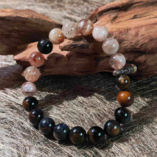 A handcrafted Tiger‘s Eye and Super Seven crystal bracelet with Tibetan silver accents, designed for grounding chaotic energy and providing spiritual protection in daily life.