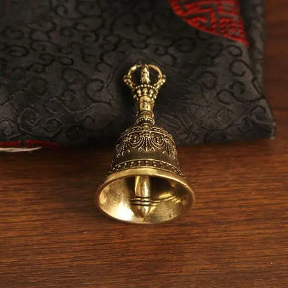 Close up detail of handcrafted vintage brass bell pendant with engraved artisan metalwork