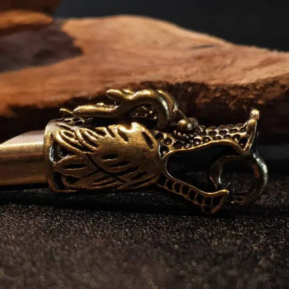 Close up detail of handcrafted brass dragon head whistle showing vintage texture and artisan design