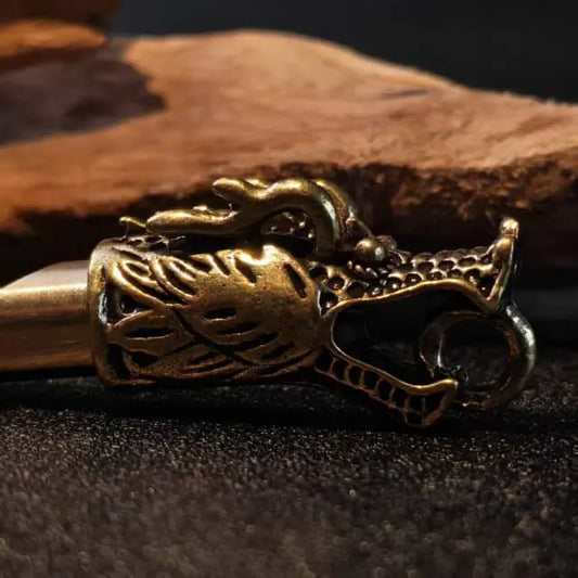 Close up detail of handcrafted brass dragon head whistle showing vintage texture and artisan design