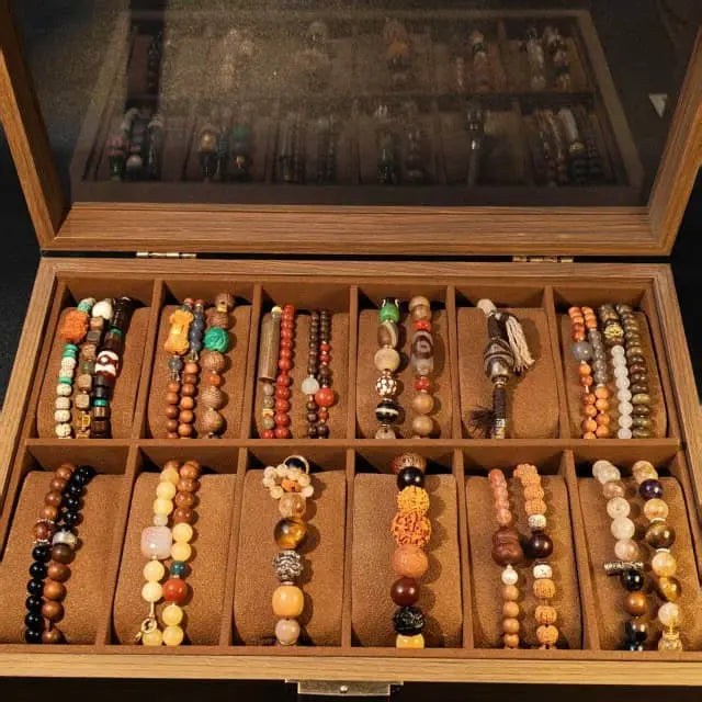 An open vintage wooden jewelry box neatly displaying a collection of colorful Tibetan-style handmade woven bracelets, featuring natural wood grain and a rustic, aged finish.