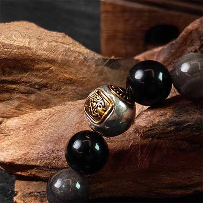  Extreme close-up detail of the silver obsidian beads and Tibetan silver spacers, highlighting the natural stone’s glossy texture, depth, and the beautiful contrast with the hand-finished metal.